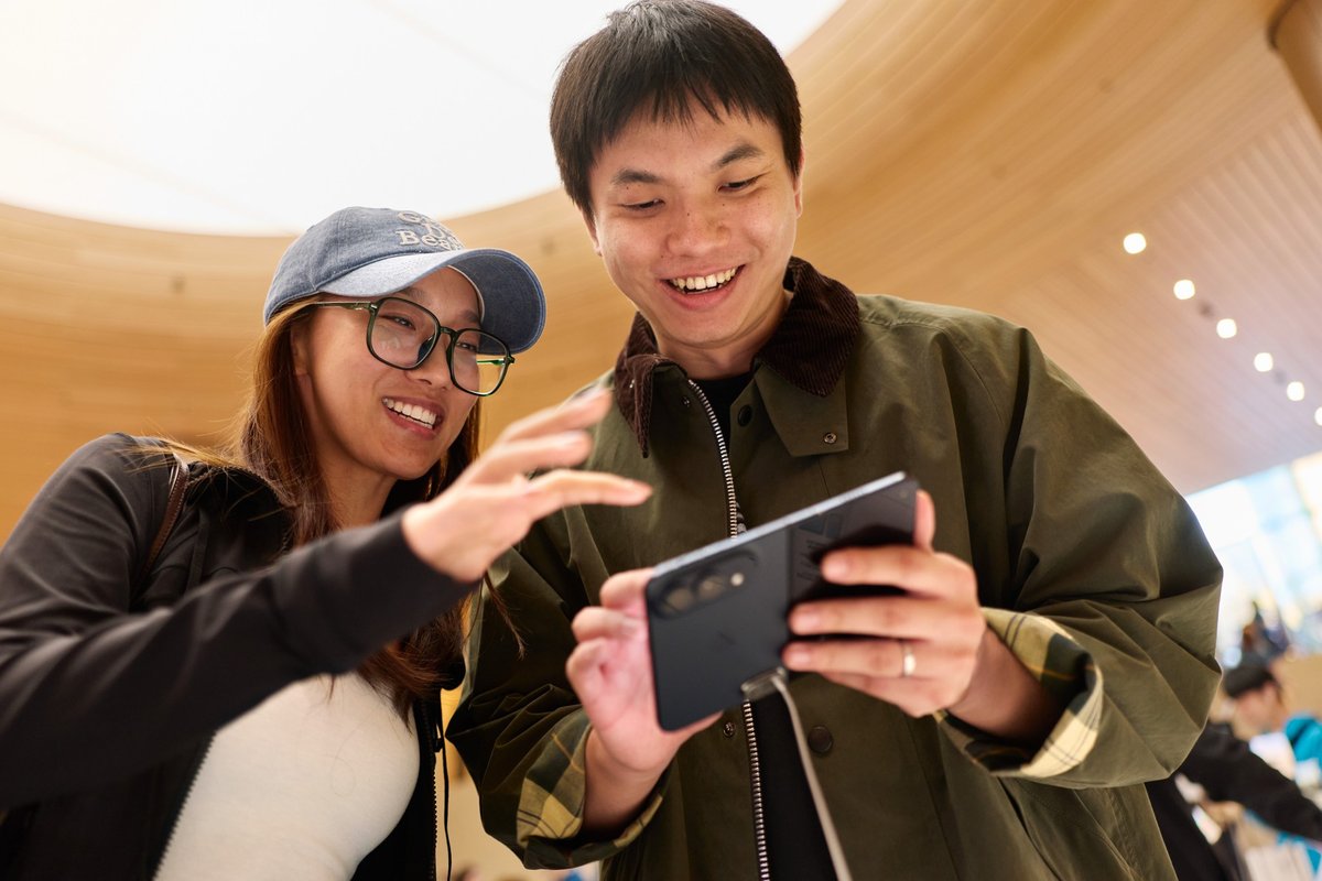 Two customers try out an iPhone Duo in Night Sky at an Apple Store on launch day