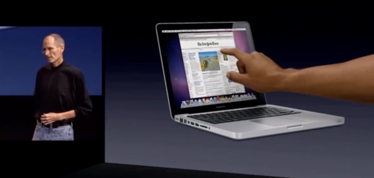 jobs-2010 | iPhone in Canada Steve Jobs on stage in 2010 reaching toward a MacBook screen while arguing against vertical touch